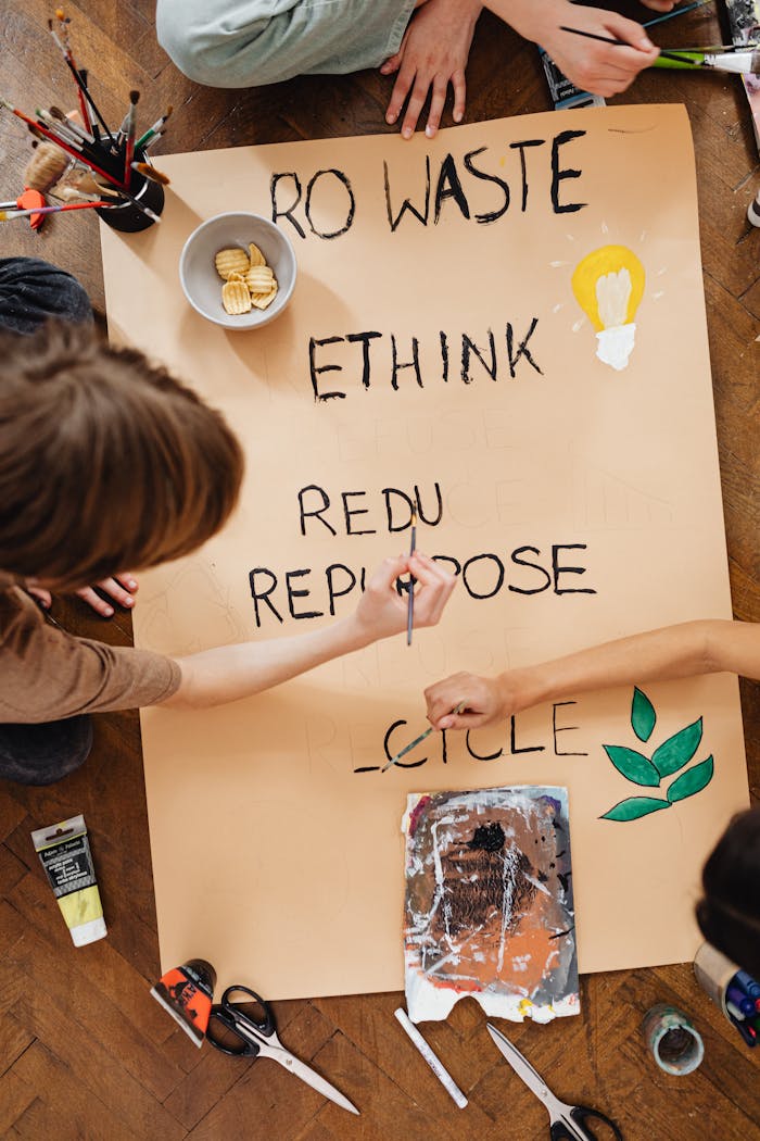 People creating a sustainable message poster with art supplies, promoting eco-awareness.
